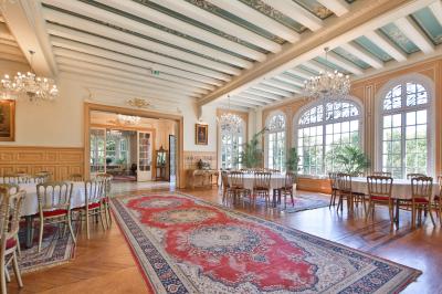 Cuisine professionnelle avec plans de travail en inox, réfrigérateurs, sol en bois clair et murs carrelés gris.