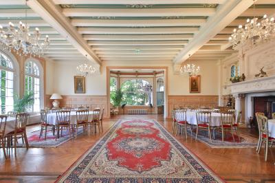 Cuisine professionnelle avec plans de travail en inox, réfrigérateurs, sol en bois clair et murs carrelés gris.