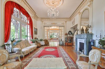 Cuisine professionnelle avec plans de travail en inox, réfrigérateurs, sol en bois clair et murs carrelés gris.