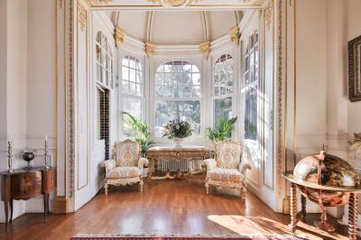 Cuisine professionnelle avec plans de travail en inox, réfrigérateurs, sol en bois clair et murs carrelés gris.