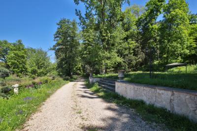Cuisine professionnelle avec plans de travail en inox, réfrigérateurs, sol en bois clair et murs carrelés gris.