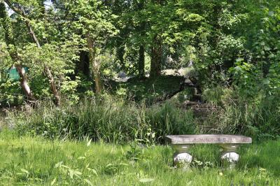 Cuisine professionnelle avec plans de travail en inox, réfrigérateurs, sol en bois clair et murs carrelés gris.