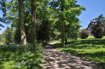 Cuisine professionnelle avec plans de travail en inox, réfrigérateurs, sol en bois clair et murs carrelés gris.