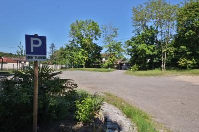 Cuisine professionnelle avec plans de travail en inox, réfrigérateurs, sol en bois clair et murs carrelés gris.