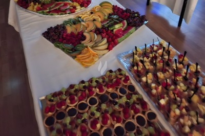 Salle décorée avec rideaux bleus, guirlandes lumineuses, vases avec fleurs et table recouverte d'une nappe blanche.