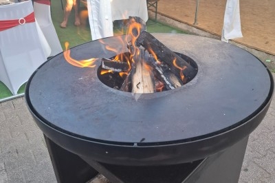 Salle décorée avec rideaux bleus, guirlandes lumineuses, vases avec fleurs et table recouverte d'une nappe blanche.