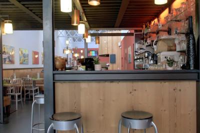 Salle de restaurant avec longues tables dressées, éclairage tamisé et effets lumineux colorés sur le sol.