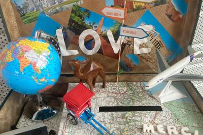 Centre de table floral avec roses blanches sur un support doré, dans une salle lumineuse avec grandes baies vitrées.