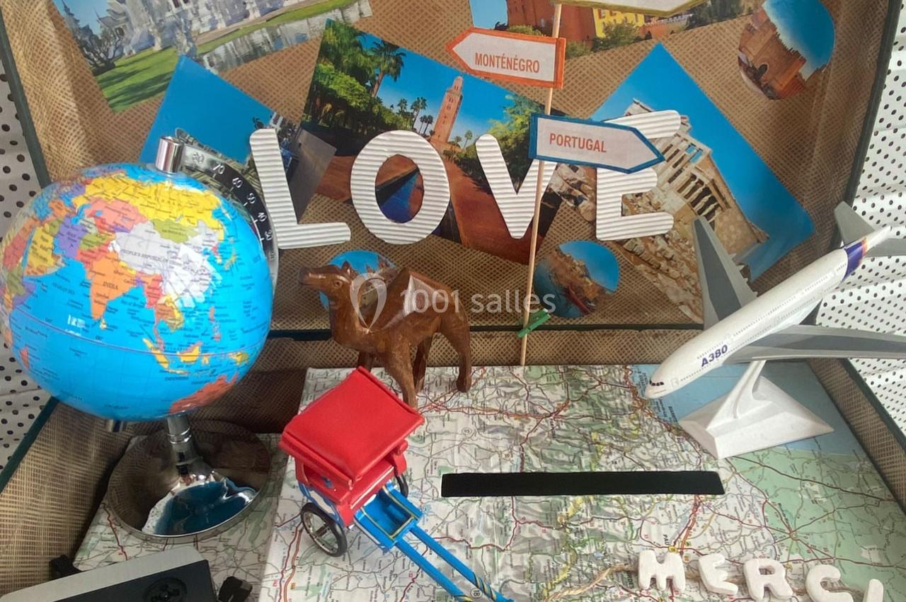 Décor évoquant le voyage avec un globe, une carte, des photos de destinations, un avion miniature et un chameau.