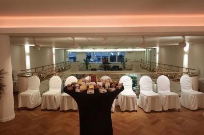 Intérieur d'un café lumineux avec canapés colorés, grandes fenêtres donnant sur une rue et un bar en arrière-plan.