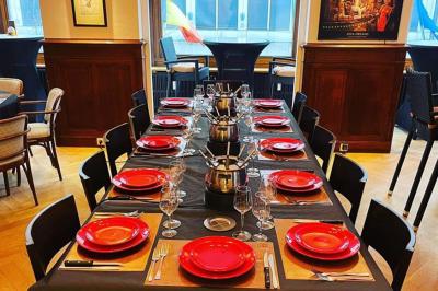 Intérieur d'un café lumineux avec canapés colorés, grandes fenêtres donnant sur une rue et un bar en arrière-plan.