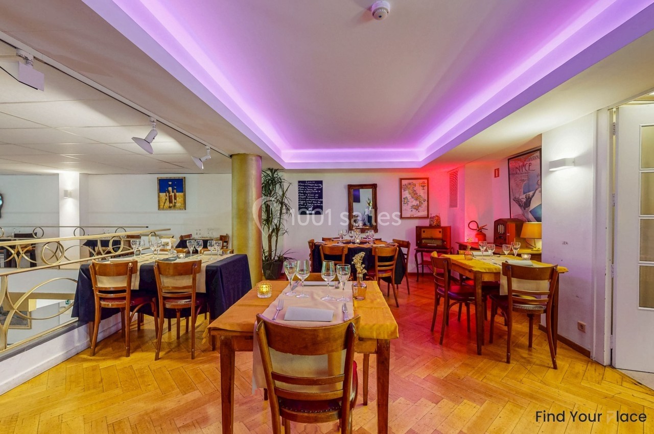 Salle de restaurant chaleureuse avec tables dressées, éclairage tamisé et décorations murales.