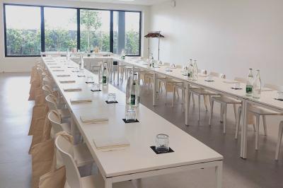 Cuisiniers en tenue blanche travaillant dans une grande cuisine professionnelle équipée d'appareils en inox.