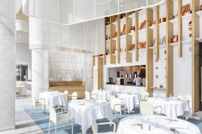 Cuisiniers en tenue blanche travaillant dans une grande cuisine professionnelle équipée d'appareils en inox.