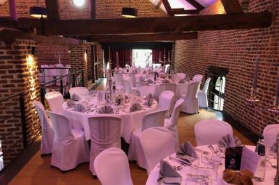 Vue d'un parc verdoyant avec des arbres, une pelouse et une rivière au premier plan, sous un ciel clair.