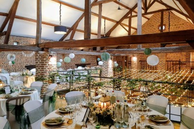 Tente éclairée par des guirlandes lumineuses dans un jardin verdoyant au crépuscule.