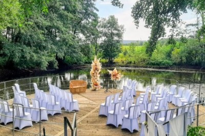 Tente éclairée par des guirlandes lumineuses dans un jardin verdoyant au crépuscule.
