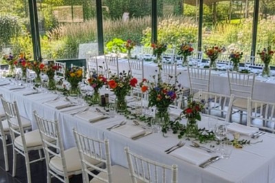 Tente éclairée par des guirlandes lumineuses dans un jardin verdoyant au crépuscule.