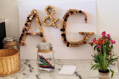 Jardin en soirée avec des arbustes fleuris, éclairé par des lampes au sol, entouré d'arbres et de végétation.