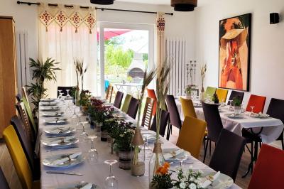 Jardin en soirée avec des arbustes fleuris, éclairé par des lampes au sol, entouré d'arbres et de végétation.