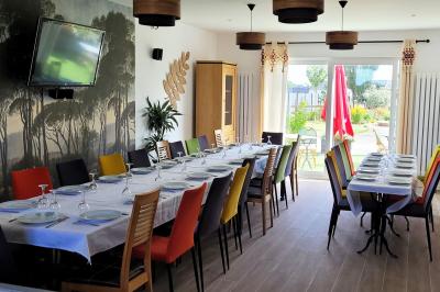 Jardin en soirée avec des arbustes fleuris, éclairé par des lampes au sol, entouré d'arbres et de végétation.