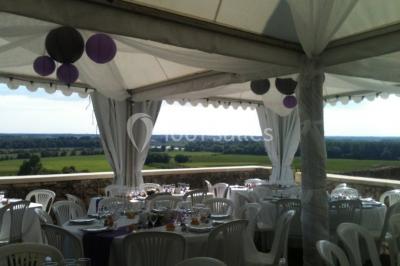 Vue nocturne d'un château en pierre éclairé par des projecteurs, mettant en valeur ses murs et ses fenêtres.