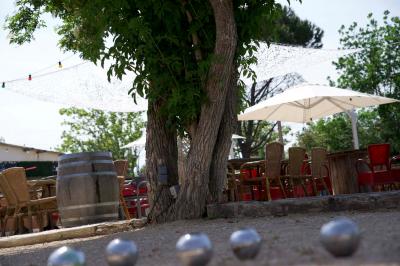Deux fauteuils en osier blanc entourés de décorations florales et de voilages, installés sur une pelouse verdoyante.