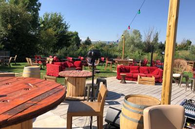 Deux fauteuils en osier blanc entourés de décorations florales et de voilages, installés sur une pelouse verdoyante.