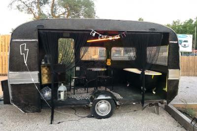 Deux fauteuils en osier blanc entourés de décorations florales et de voilages, installés sur une pelouse verdoyante.