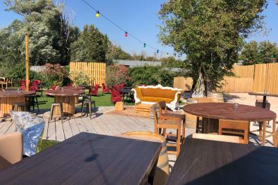 Deux fauteuils en osier blanc entourés de décorations florales et de voilages, installés sur une pelouse verdoyante.