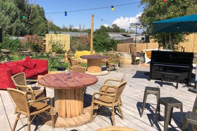 Deux fauteuils en osier blanc entourés de décorations florales et de voilages, installés sur une pelouse verdoyante.