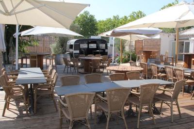 Deux fauteuils en osier blanc entourés de décorations florales et de voilages, installés sur une pelouse verdoyante.