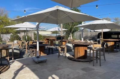 Deux fauteuils en osier blanc entourés de décorations florales et de voilages, installés sur une pelouse verdoyante.