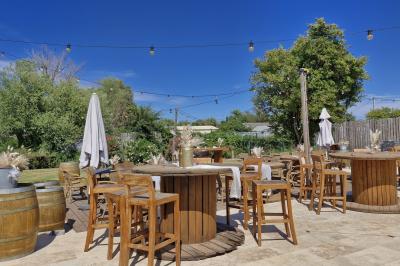 Deux fauteuils en osier blanc entourés de décorations florales et de voilages, installés sur une pelouse verdoyante.