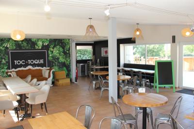 Deux fauteuils en osier blanc entourés de décorations florales et de voilages, installés sur une pelouse verdoyante.