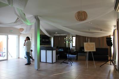 Deux fauteuils en osier blanc entourés de décorations florales et de voilages, installés sur une pelouse verdoyante.