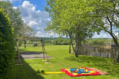 Salle en pierre décorée avec des cadres photo, des chaises blanches et des bougies sur une table.