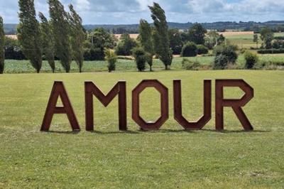 Salle en pierre décorée avec des cadres photo, des chaises blanches et des bougies sur une table.