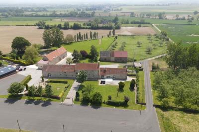 Salle en pierre décorée avec des cadres photo, des chaises blanches et des bougies sur une table.