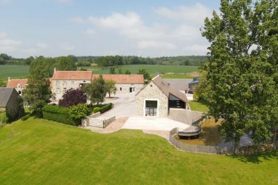 Salle en pierre décorée avec des cadres photo, des chaises blanches et des bougies sur une table.