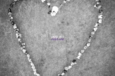 Un couple de mariés s'embrasse sous une haie d'honneur formée par des pompiers tenant des roses rouges.