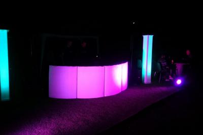 Un couple de mariés s'embrasse sous une haie d'honneur formée par des pompiers tenant des roses rouges.