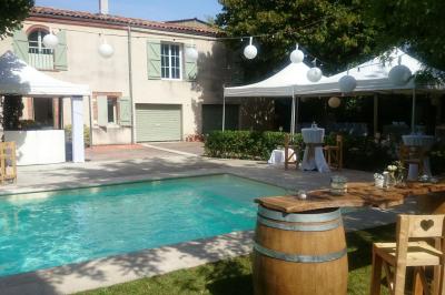 Un couple de mariés s'embrasse sous une haie d'honneur formée par des pompiers tenant des roses rouges.