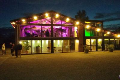 Un couple de mariés s'embrasse sous une haie d'honneur formée par des pompiers tenant des roses rouges.