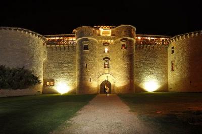 Un couple de mariés s'embrasse sous une haie d'honneur formée par des pompiers tenant des roses rouges.