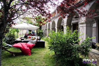 Un couple de mariés s'embrasse sous une haie d'honneur formée par des pompiers tenant des roses rouges.