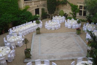 Un couple de mariés s'embrasse sous une haie d'honneur formée par des pompiers tenant des roses rouges.