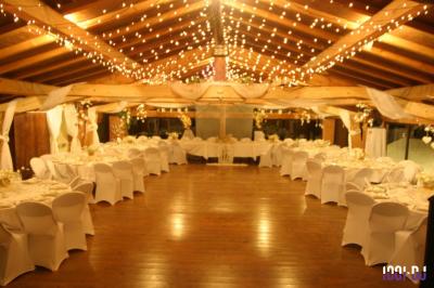 Un couple de mariés s'embrasse sous une haie d'honneur formée par des pompiers tenant des roses rouges.