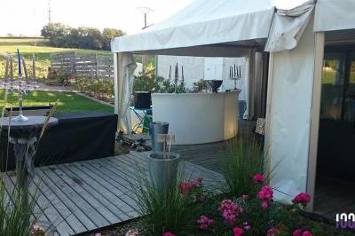Un couple de mariés s'embrasse sous une haie d'honneur formée par des pompiers tenant des roses rouges.