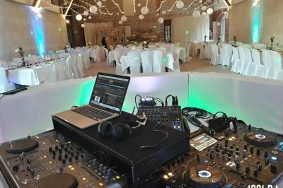 Un couple de mariés s'embrasse sous une haie d'honneur formée par des pompiers tenant des roses rouges.